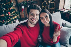 Top above angle photo of two people romantic guy and lady make v-signs selfie have christmas vacation x-mas holidays sit on divan in  house with newyear decoration illlumination indoors