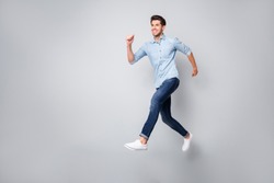 Full length body size photo of cheerful handsome attractive guy wearing white sneakers isolated over grey color background running towards his dream
