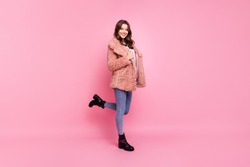 Full length profile photo of amazing millennial model lady standing confidently wearing stylish youth fluffy autumn jacket jeans shoes isolated pink background
