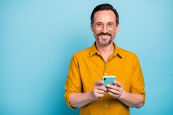 Portrait of positive cool man use cellphone read social media news information blogging post comment wear good looking shirt isolated over blue color background