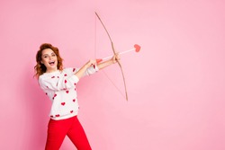 Portrait of her she nice attractive lovely pretty amorous cheerful cheery glad positive wavy-haired girl angel shooting arrow match isolated on pink pastel color background