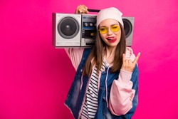 Close-up portrait of her she nice attractive cheerful cheery girl carrying boombox showing horn sign grimacing having fun isolated on bright vivid shine vibrant pink fuchsia color background