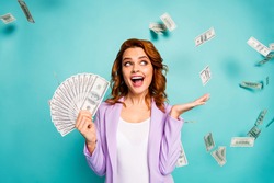 Shocked crazy professional woman hold money fan lottery earnings hold hand impressed dollars falling fluying wear violet formalwear jacket isolated teal turquoise color background