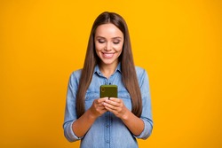 Portrait of positive cheerful girl use smartphone read social network novelties enjoy online communication wear good look clothes isolated over bright shine color background