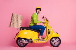 Profile side view of his he nice attractive crazy overjoyed cheerful cheery guy driving moped bringing pile stack pizza order punctuality isolated over pink pastel color background