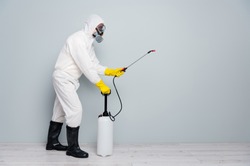 Full body photo of professional specialist guy disinfectant cleaning public transport during pandemic spraying surface wear white hazmat protective suit isolated grey color background