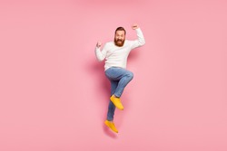 Full body photo of excited energetic guy jump celebrate discount lottery win raise fists scream yeah wear white sweater shine footwear isolated over pastel color background