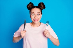 Photo of pretty funny hungry lady two funny buns hold metal fork knife wait to try tasty meal excited dinner start wear casual pink t-shirt isolated bright blue color background