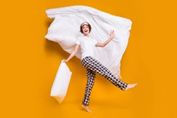Full length photo of cheerful lady blanket flying above head playful mood dancing energetic morning wear mask white t-shirt plaid pajama pants barefoot isolated yellow color background
