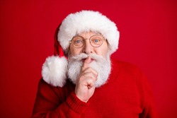 Hush i prepare x-mas gifts. Serious magic old retired pensioner man put finger lips keep voiceless speechless private season newyear news wear bright jumper isolated shine color background