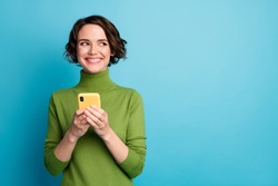 Portrait of positive cheerful girl use smart phone look copyspace share social media news wear style stylish trendy jumper isolated over blue color background