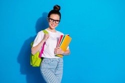 Portrait of her she nice attractive pretty lovely cheerful cheery girl diligent nerd going back to school carrying subject exercise book isolated bright vivid sine vibrant blue color background
