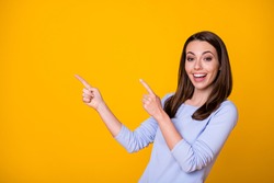 Photo of attractive cheerful excited lady direct fingers side empty space good mood showing novelty banner shopping season opening wear casual shirt isolated yellow color background