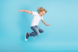 Profile photo of young boy jump fly movement hands wear white shirt jeans sneakers isolated blue color background
