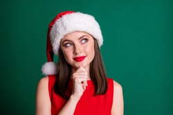 Closeup photo of charming x-mas party character lady look side empty space arm chin dreamer wait miracle magic watch sky stars wear santa cap isolated green pastel color background