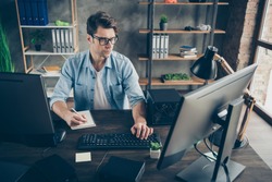 Portrait of his he nice attractive focused experienced geek guy writing plan finance growth programming cyberspace algorithm at modern loft brick interior style work place station indoors