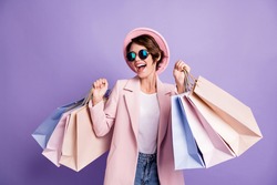 Photo of amazed pretty optimistic brunette young lady do shopping wear glasses pink cap coat isolated on purple color background