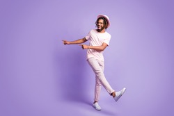 Full size photo of young afro funky crazy smiling man guy male pointing fingers in copyspace isolated on violet color background