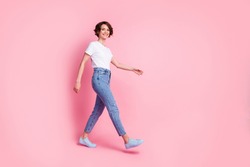 Full length body size profile side view of nice cheerful cheery brown-haired girl wearing comfy clothes walking isolated over pink color background