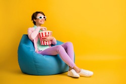 Full length body size photo woman 3d glasses watching comedy tv eating pop corn beanbag isolated on bright yellow color background copyspace
