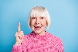 Photo portrait of happy old lady having idea raising finger up isolated on pastel blue colored background