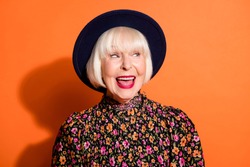 Headshot of sly curious old woman looking blank space smiling red lipstick wearing blouse headwear isolated vivid orange color background
