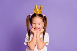 Photo of charming little princess girl hold hands cheekbones good mood isolated on purple color background