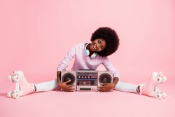 Portrait of nice cheerful wavy-haired girl wearing rollers listening hugging tape player free time isolated over pink pastel color background