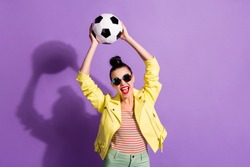 Photo of young happy excited positive girl woman female with open mouth hold soccer ball above head isolated on violet color background
