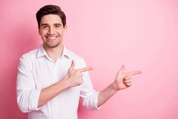 Portrait of optimistic funny guy point empty space wear white shirt isolated on pink color background