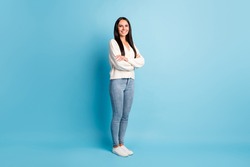 Full length profile portrait of half turned nice girl crossed arms smile look camera isolated on blue color background