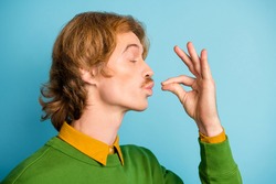 Profile side photo of young handsome funky funny man tasting enjoying delicisous food isolated on blue color background