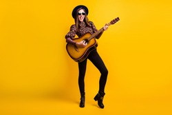Full length body size photo of happy brunette playing acoustic guitar overjoyed isolated vibrant yellow color background