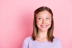 Photo of dreamy cute positive little girl look empty space wonder smile isolated on pastel pink color background