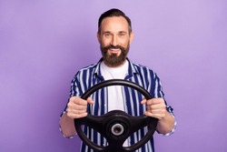 Photo of mature man driver hold steering wheel isolated over purple color background