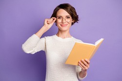 Photo portrait of clever female student touching spectacles keeping book isolated on bright violet color background