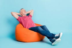 Full length body size photo of bearded man getting rest at work in beanbag isolated pastel blue color background