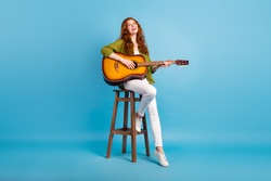 Full length body size view of pretty cheerful girl playing guitar singing hit isolated over pastel blue color background