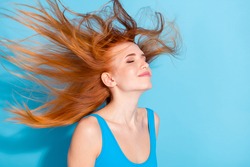 Photo portrait red haired woman happy dreamy windy weather flying hair isolated pastel blue color background