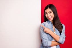 Portrait of lovely trendy cheerful girl demonstrating big board advert novelty message isolated over bright red color background