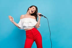Portrait of attractive cheerful careless dreamy girl singing hit having fun rest isolated over vibrant blue color background