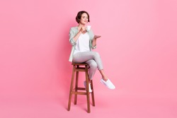 Full length photo of lovely bob hairdo millennial lady sit chair drink wear grey green outfit isolated on pink color background