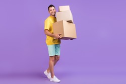 Full body photo of happy cheerful man hold hand boxes smile move houses isolated on purple color background