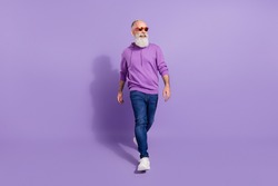 Full length body size view of attractive cheerful grey-haired man going isolated over purple violet color background