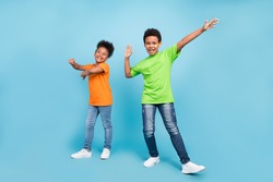 Full length photo of small funny brunet boy girl dance wear t-shirt jeans shoes isolated on blue color background