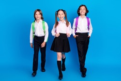 Photo of joyful school children stroll back to school wear rucksack uniform shoes isolated blue color background