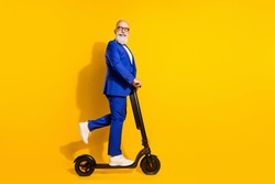 Full length body size profile side view of nice cheerful chic man riding scooter having fun isolated over bright yellow color background