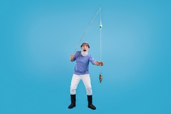 Full size photo of happy cool positive amazed old man hold hand fishing rod catch isolated on blue color background