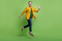 Full size profile side photo of mature man happy positive smile jump go walk run isolated over green color background