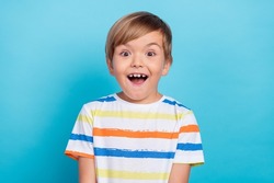 Photo of little funny blond boy wear white t-shirt isolated on blue color background